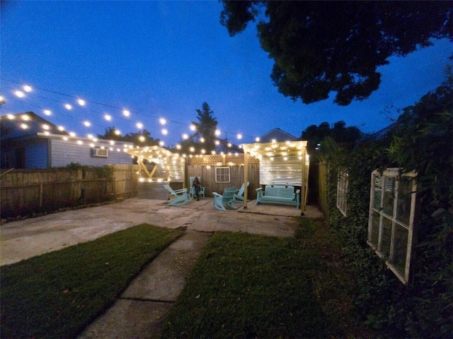 yard at night featuring a patio