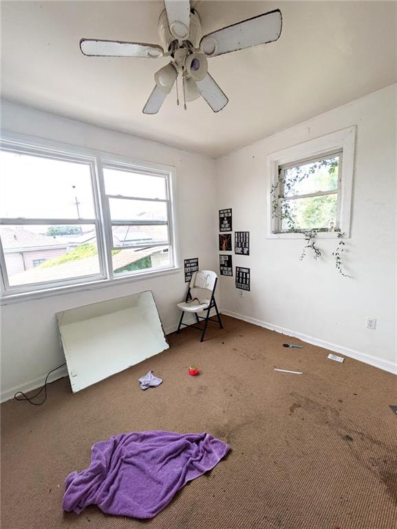 interior space with multiple windows and ceiling fan