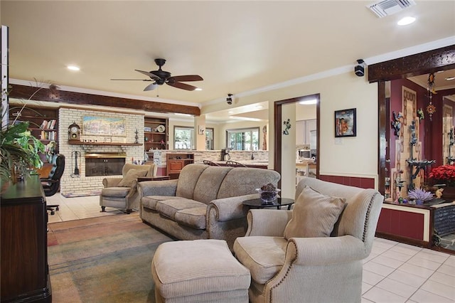 living room with ceiling fan, light tile patterned floors, a fireplace, and ornamental molding