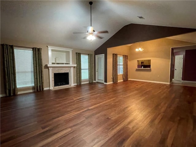 unfurnished living room featuring ceiling fan with notable chandelier, dark hardwood / wood-style floors, and lofted ceiling