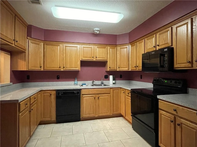 kitchen featuring sink, a textured ceiling, black appliances, and light tile floors