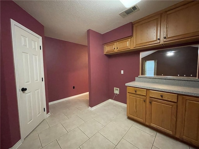 kitchen with a textured ceiling and light tile floors