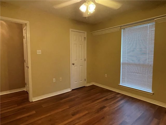 spare room featuring ceiling fan and dark hardwood / wood-style flooring