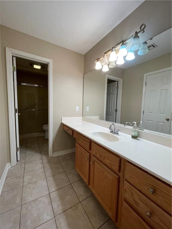 bathroom featuring tile flooring, toilet, and vanity