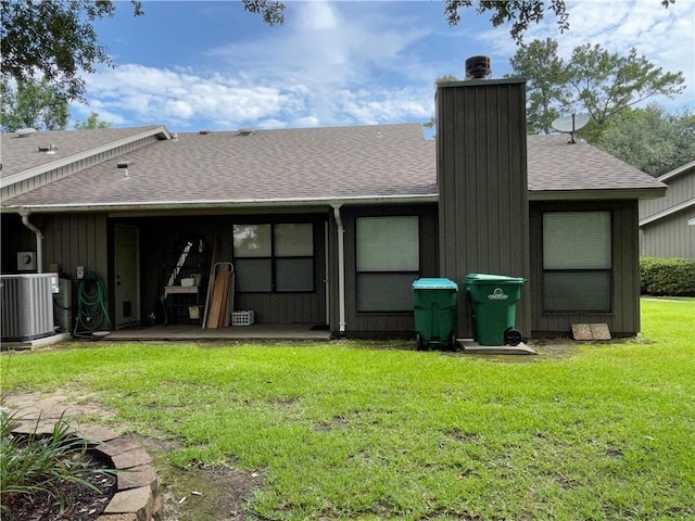 rear view of house with a patio, central AC unit, and a lawn