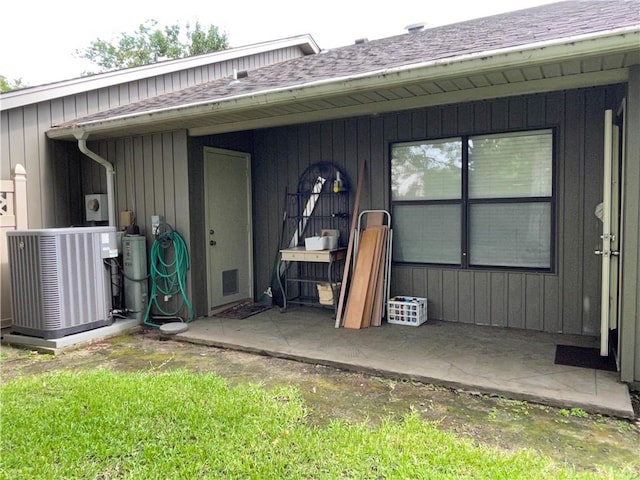 view of exterior entry with a patio and central AC unit