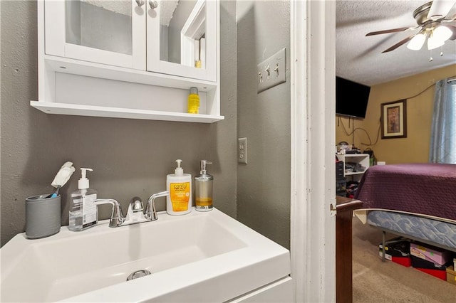 bathroom featuring sink, ceiling fan, and a textured ceiling