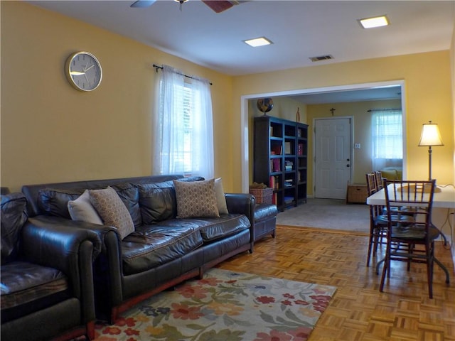 living room featuring light parquet flooring and ceiling fan