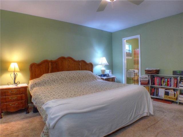 bedroom with ceiling fan, light carpet, and ensuite bath