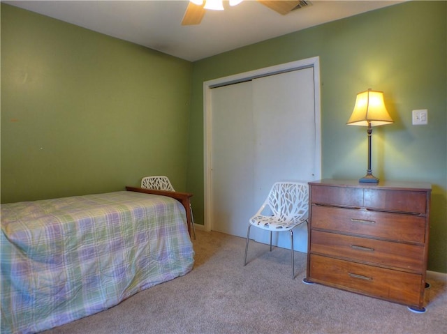 carpeted bedroom with ceiling fan and a closet