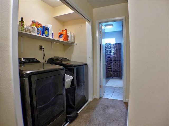 clothes washing area featuring washing machine and clothes dryer and carpet