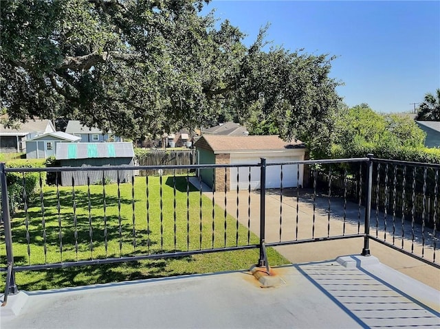 view of gate featuring a lawn and an outdoor structure