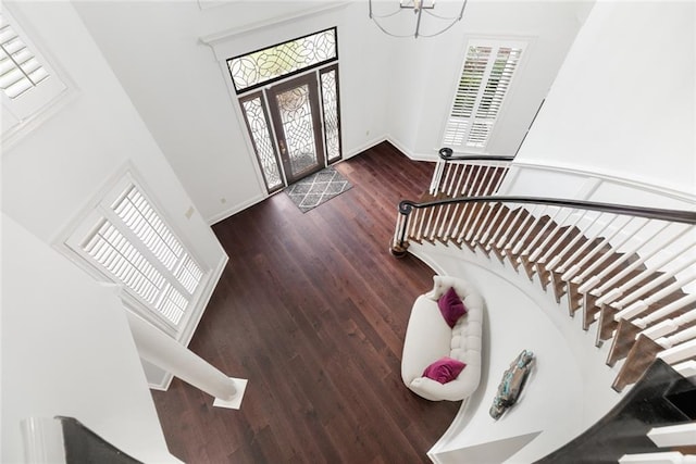 foyer entrance with an inviting chandelier, a high ceiling, and dark hardwood / wood-style floors