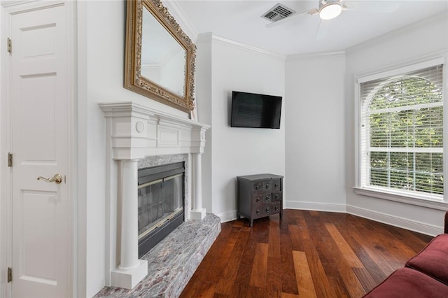 living room featuring dark hardwood / wood-style floors, ornamental molding, ceiling fan, and a high end fireplace