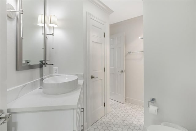 bathroom featuring tile flooring, vanity, and toilet