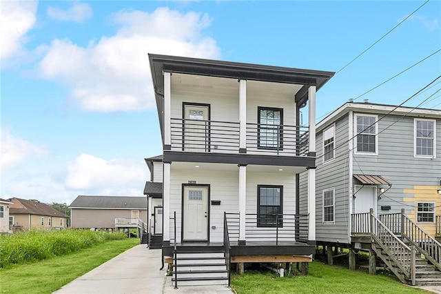 view of front of property with a balcony and a front lawn