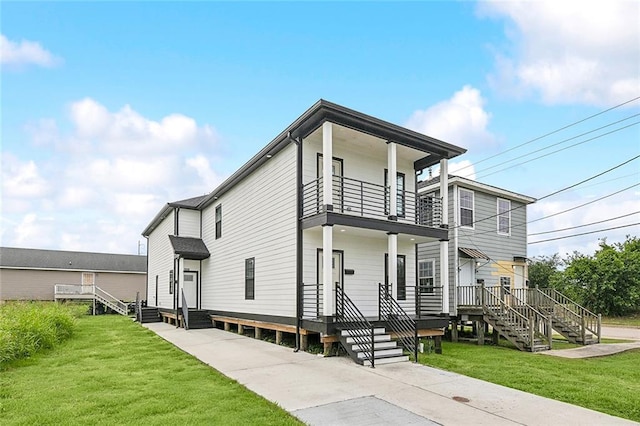 view of front facade with a balcony and a front lawn