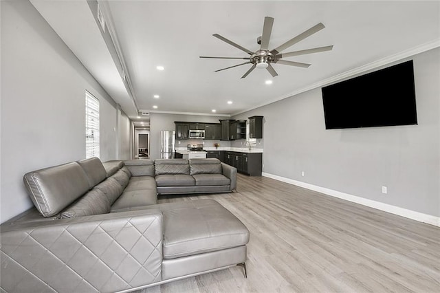 living room with sink, ornamental molding, ceiling fan, and light hardwood / wood-style flooring