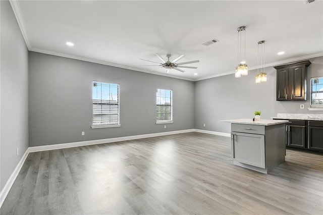 kitchen featuring light hardwood / wood-style floors, a kitchen island, ceiling fan, ornamental molding, and pendant lighting