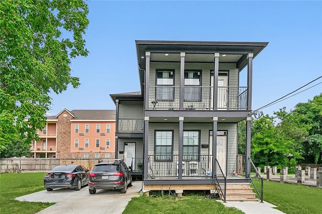 view of front of home with a front yard, covered porch, and a balcony