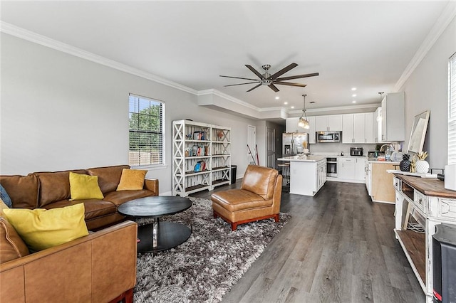 living room with wood-type flooring, ornamental molding, and ceiling fan