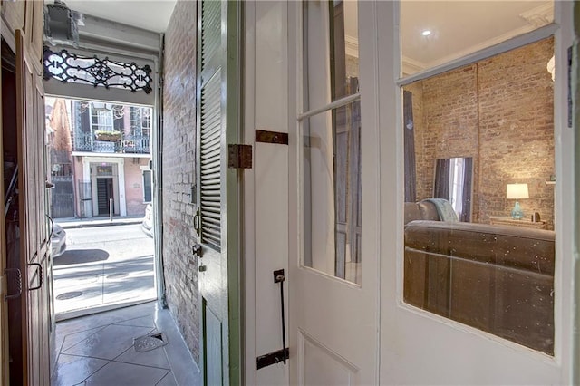 entryway featuring tile floors and crown molding