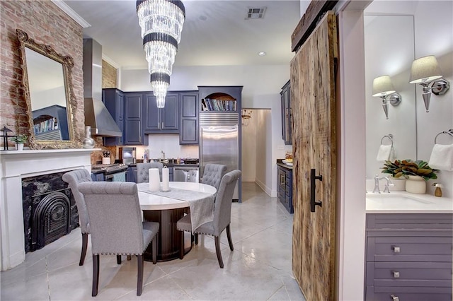 tiled dining room with a chandelier, sink, brick wall, and crown molding