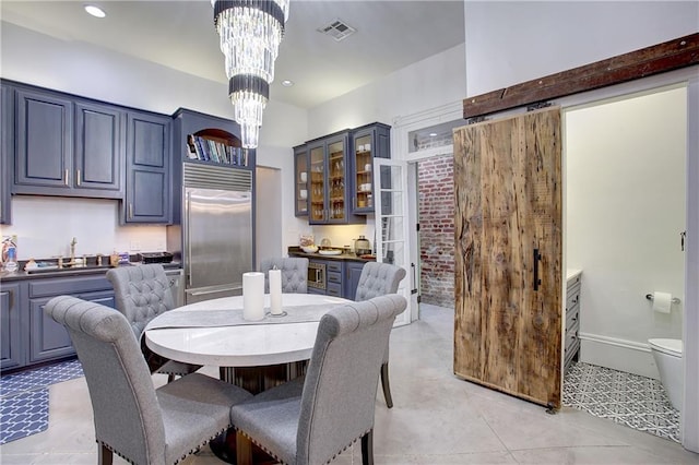 dining room featuring sink, a chandelier, and light tile floors