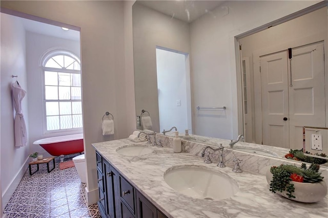 bathroom with tile flooring, large vanity, toilet, and dual sinks