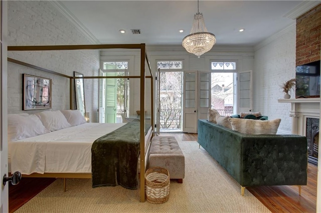 bedroom featuring a notable chandelier, ornamental molding, hardwood / wood-style floors, and access to exterior