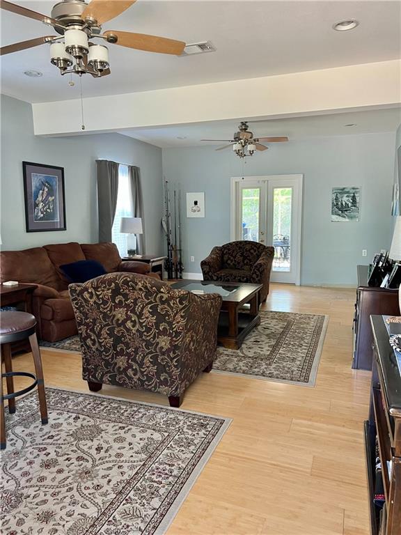 living room with ceiling fan, french doors, and light hardwood / wood-style flooring