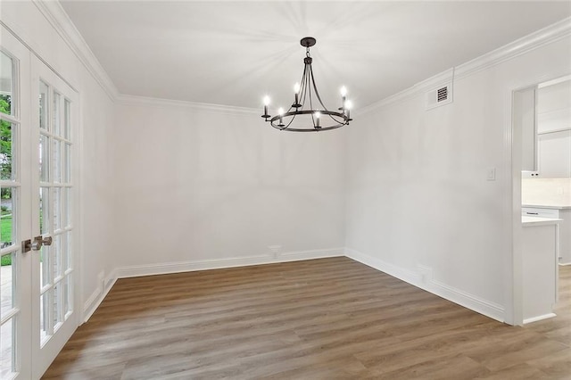 unfurnished dining area with light hardwood / wood-style flooring, crown molding, a chandelier, and french doors