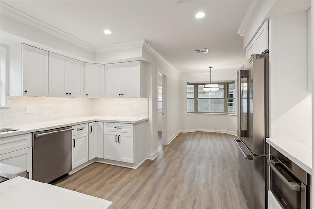 kitchen featuring stainless steel appliances, tasteful backsplash, and light hardwood / wood-style flooring