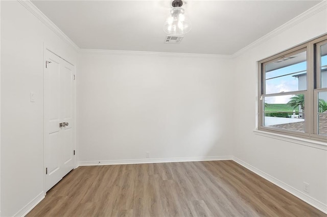 empty room with ornamental molding and hardwood / wood-style flooring