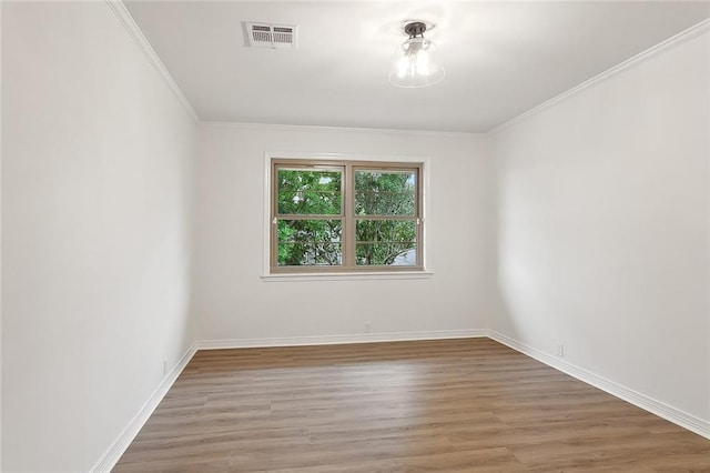 empty room featuring hardwood / wood-style flooring and crown molding