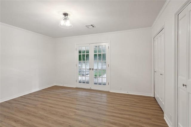 unfurnished bedroom featuring french doors, crown molding, and wood-type flooring