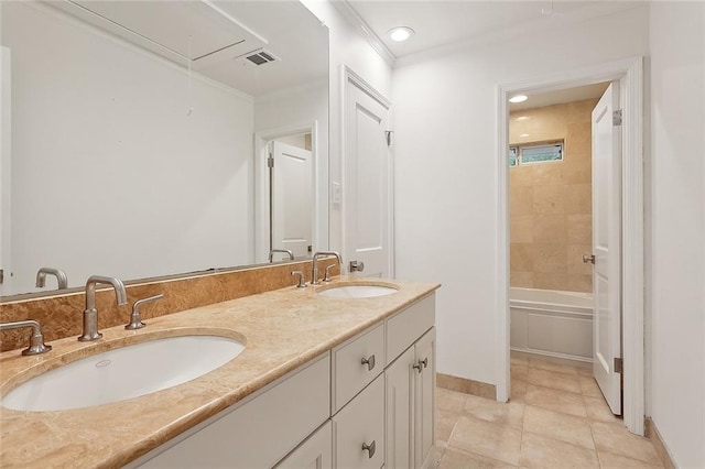 bathroom featuring tiled shower / bath, ornamental molding, vanity, and tile patterned floors