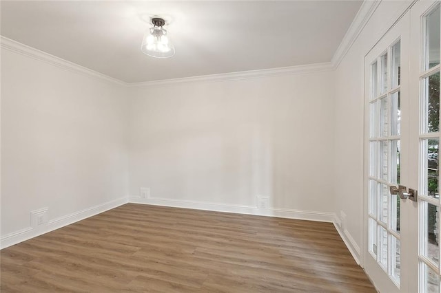 empty room with hardwood / wood-style flooring, crown molding, and french doors