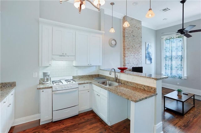 kitchen with white gas range oven, ornamental molding, dark hardwood / wood-style floors, kitchen peninsula, and ceiling fan