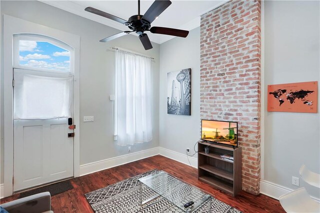 foyer entrance with brick wall, ceiling fan, and dark hardwood / wood-style floors