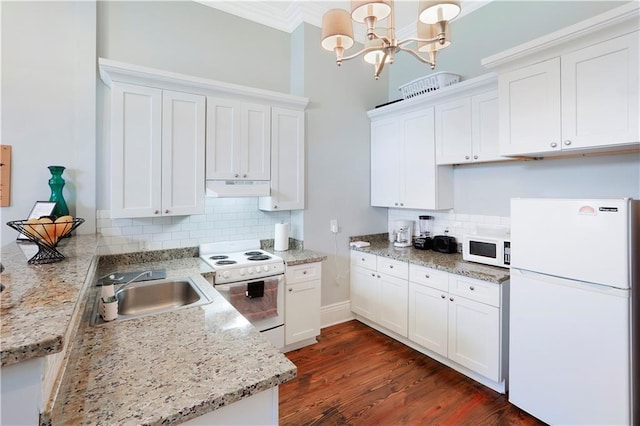 kitchen featuring dark wood-type flooring, white appliances, pendant lighting, and backsplash