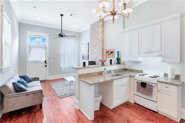 kitchen with kitchen peninsula, hardwood / wood-style floors, tasteful backsplash, electric range, and hanging light fixtures