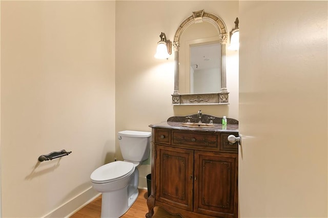 bathroom with wood-type flooring, vanity, and toilet