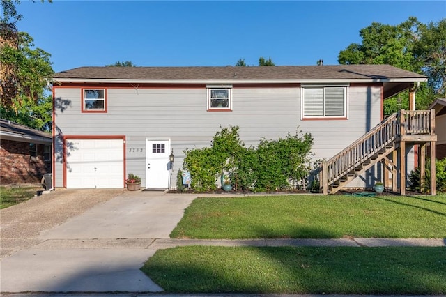 view of front of home featuring a front yard, a garage, and a deck