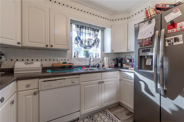 kitchen featuring white dishwasher, stainless steel fridge with ice dispenser, white cabinets, backsplash, and sink