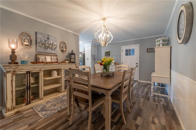 dining area with an inviting chandelier, ornamental molding, and dark hardwood / wood-style floors