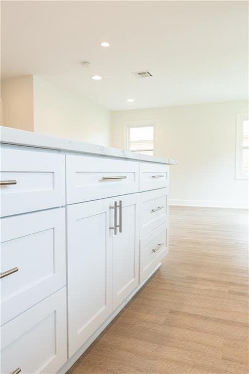 kitchen featuring white cabinets and light hardwood / wood-style flooring