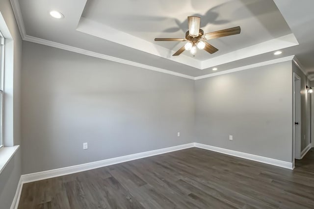 unfurnished room with a tray ceiling, dark hardwood / wood-style floors, and ceiling fan