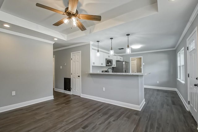 kitchen with white cabinetry, dark hardwood / wood-style flooring, appliances with stainless steel finishes, kitchen peninsula, and a raised ceiling