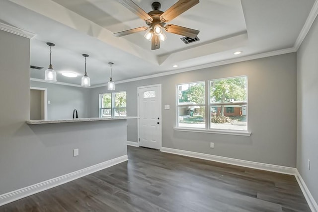 interior space featuring ceiling fan, a tray ceiling, dark hardwood / wood-style floors, and crown molding